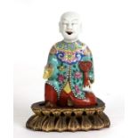 A 19th century Chinese famille rose incense holder in the form of a kneeling robed figure holding