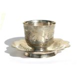 A Chinese white metal cup & saucer with engraved foliate decoration and calligraphy, the saucer