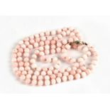 An angel skin coral bead necklace with 9ct gold clasp, each bead approx 6mm diameter, overall