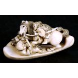 A 19th century Japanese ivory netsuke in the form of a Samurai on horseback riding over a fallen
