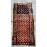 A Persian Kurdish hand knotted woollen runner with geometric design on a beige ground,