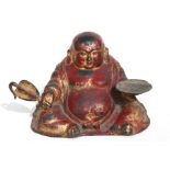 A Chinese gilt and lacquered bronze figure of a Buddha holding a dish in one hand and a fan in the
