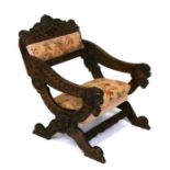 A continental oak chair with upholstered seat and back, the crest rail carved with North Wind mask