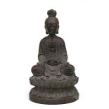 A Chinese bamboo carving in the form on Guanyin seated on a lotus flower, 29cms (11.5ins) high.