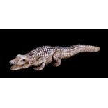 A late 19th / early 20th century Japanese ivory netsuki in the form of a crocodile, signed to