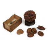 Four 19th century Chinese carved peach nut buttons or beads; together with a carved heido nut and