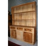 A 19th century stripped pine dresser with three frieze drawers with cupboards beneath, 183cms (