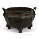 A large Japanese bronze two-handled censer or planter of octagonal form, decorated with dragons,