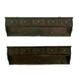 A pair of oak wall shelves, each with five short drawers, 110cms (43.5ins) wide (2).