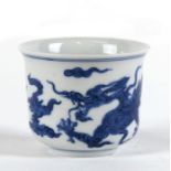 A Chinese blue & white tea bowl decorated in the Ming style, with a dragon amongst clouds, 66cms (