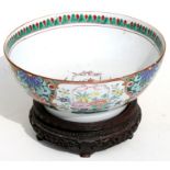 A 19th century Chinese famille rose bowl on a hardwood stand, 25cms (9.75ins) diameter.