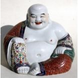 A Chinese famille rose figure in the form of a seated Buddha, impressed mark to underside, 26cms (