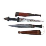 Two African tribal daggers in leather sheaths. Blade lengths of 22.5cms (8.875ins) and 17.5cms (6.