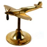 A brass model of the WW2 fighter the Supermarine Spitfire with spinning propeller mounted on its