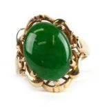 An 18ct gold ring set with an oval jade cabochon, approx UK size 'L'.