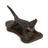 A 19th century cast iron cork press in the form of a stylised crocodile, 29cms (11.5ins) long.