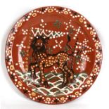 A slipware charger decorated with a stylised lion, 42cms (16.5ins) diameter.