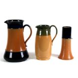 Two Royal Doulton Stoneware jugs, the largest,24cms (9.5ins) high; together with a similar vase,