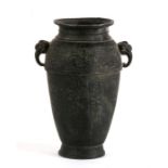 An archaic style bronze vase with elephant head handles, 12cms (4.25ins) high.