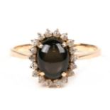 A 14ct gold dress ring set with a central black cabochon, approx UK size 'S'.