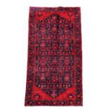 A Persian Hamadan woollen hand knotted runner with repeated design within a floral border, on a