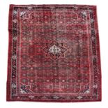 A Persian Hamadan woollen hand knotted rug with central floral medallion with floral borders on a