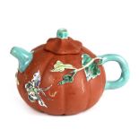 A Chinese Yixing pottery teapot in the form of a melon with enamelled foliage and butterfly
