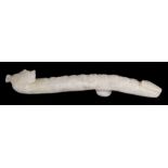 A Chinese jade or hardstone belt hook in the form of a dragon, 11cms (4.25ins) long.