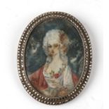 A silver and marcasite oval brooch containing a watercolour portrait miniature of a young woman