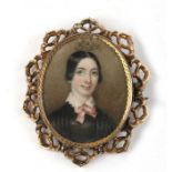 A 19th century glazed back portrait miniature brooch of a young girl, within a pierced 9ct gold