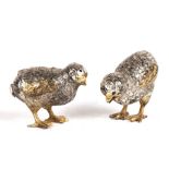 A pair of Italian silver and gilt salt and peppers in the form of quails, 5cms (2ins) high.