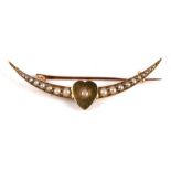 An 18ct gold (unmarked but tested) crescent shaped bar brooch with heart shaped central motif, set