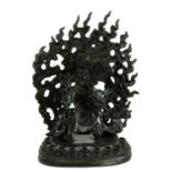 A Tibetan bronze figure of a deity on stand, with flaming mandala, 17.5cms (7 ins) high.