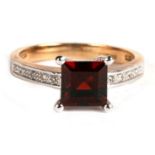 A 9ct gold garnet and diamond ring, the central square cut garnet with diamond shoulders, approx