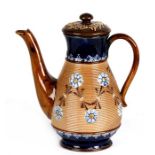 A Doulton Lambeth coffee pot decorated with flowers, 20cms (8ins) high.