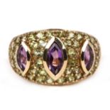 A 9ct gold dress ring set with three amethysts and a multitude of green stones, approx UK size 'L'.