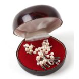 A sterling silver and pearl brooch; together with matching screw back earrings.