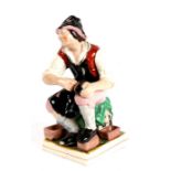 A Staffordshire pottery figure in the form of a cobbler, 31cms (12.75ins) high.