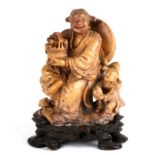 A Chinese soapstone group depicting a robed woman holding a basket of flowers with a child beside,