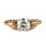 A 10ct gold dress ring set with a single large white stone, possible a white sapphire, approx UK