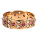 A 9ct gold eternity ring set with rubies and white stones, approx UK size 'O'.