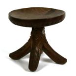Tribal Art. A Nigerian stool carved from a single piece with four splayed legs and all over