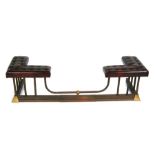 An extending brass and leather upholstered club fender, 164cms (64.5ins) fully extended.Condition