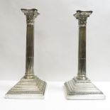 A pair of silver plated Corinthian column candlesticks, each with a detachable sconce, on stepped