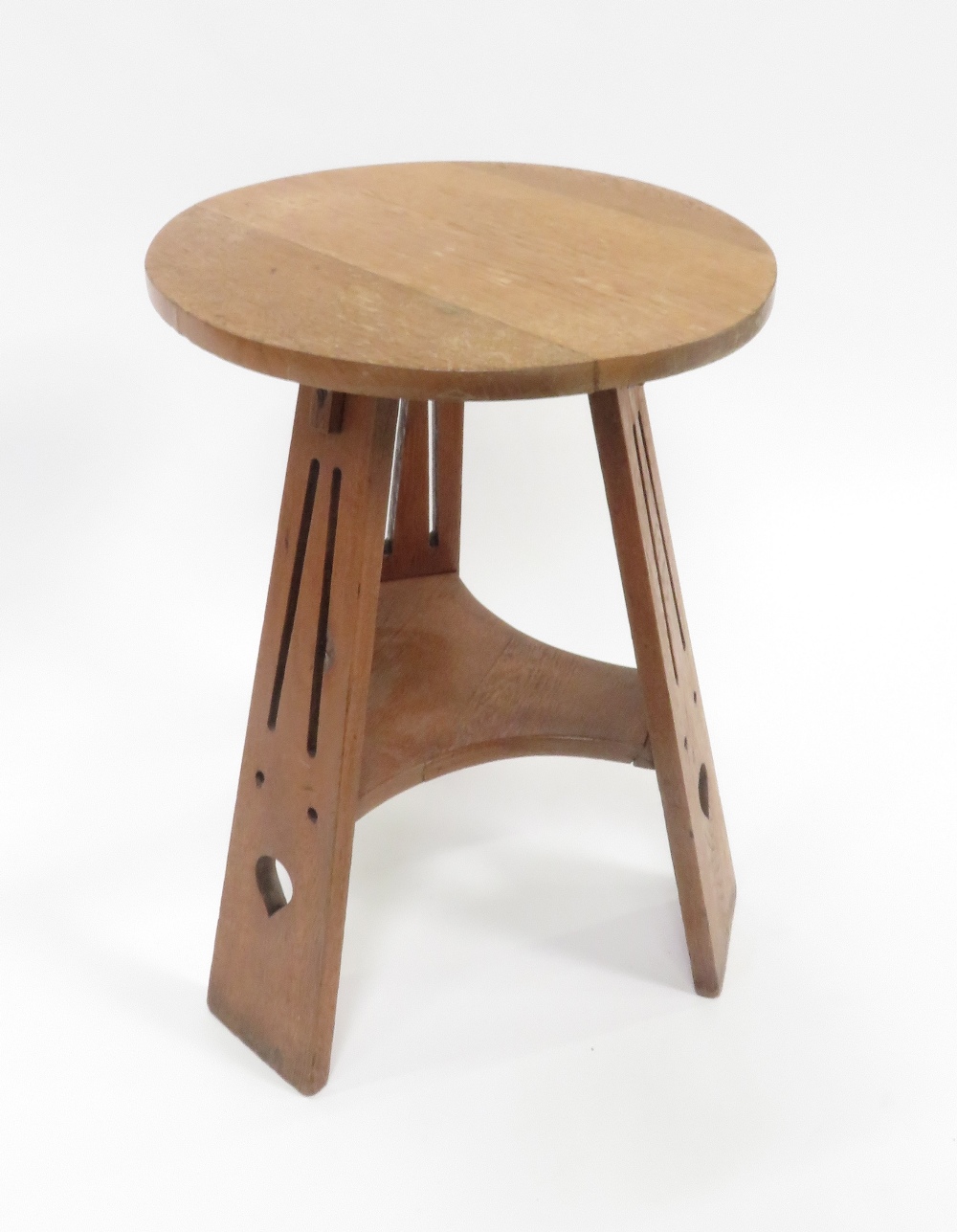 An Arts & Crafts oak tripod table, with pierced motifs, 64.5cm high, 44cm diameter