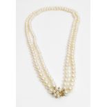 A two row uniform cultured pearl necklace, to a 9 carat gold cultured pearl cluster clasp, the 82