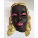 A Goldscheider style mask, modelled as a female with blonde plaits, with a black backstamp, 20cm