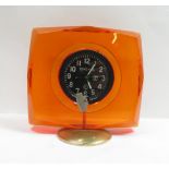 A Russian dashboard aircraft clock, mounted in a red perspex circular pedestal stand