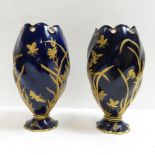 A pair of Coalport vases, gilded in relief flowers, plants and butterflies on blue ground, each with