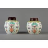 A pair of Chinese famille rose floral ginger jars and wooden covers, Qianlong mark, 19th C.